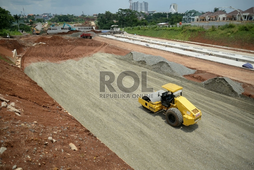 Pekerja dibantu alat berat menyelesaikan pembangunan proyek Tol Cijago, di Jalan Juanda, Depok, Jawa Barat, Senin(9/3). 