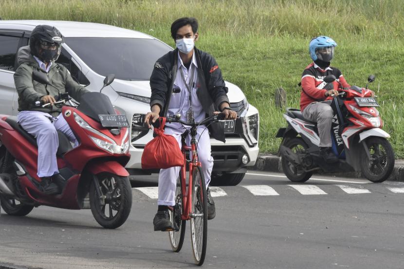 Pekerja industri bersepeda sepulang kerja di kawasan industri MM 2100, Cikarang, Kabupaten Bekasi, Jawa Barat, Rabu (3/2/2021). Satuan Tugas Percepatan Penanganan COVID-19 Kabupaten Bekasi mempersiapkan tes usap massal kedua bagi 5.000 pekerja industri karena masih tingginya kasus terkonfirmasi positif COVID-19.