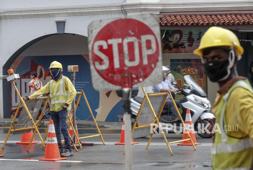 Singapura merahasiakan identitas WNI terinfeksi Corona. Pekerja konstruksi memakai masker di sepanjang jalan di Singapura, Rabu (29/1/2020). Tujuh orang berasal dari Wuhan, Cina telah dinyatakan positif terkena virus corona di Singapura.