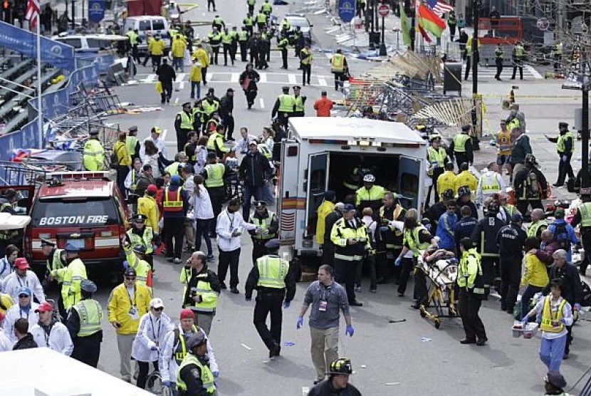 Pekerja medis mebantu para korban terluka akibat ledakan bom di garis finis pada perlombaan Maraton Boston 2013 pada 15 April 2013