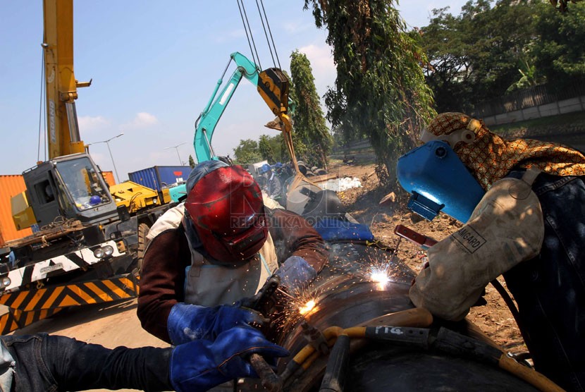  Pekerja melakukan pemasangan pipa aliran gas di Kawasan Berikat Nusantara Cilincing, Jakarta, Jumat (23/5). 