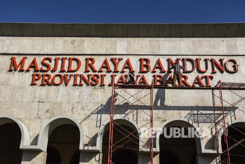 Pekerja melakukan pembersihan dan mengecat ulang papan nama Masjid Raya Bandung, Kota Bandung, Jumat (3/5).