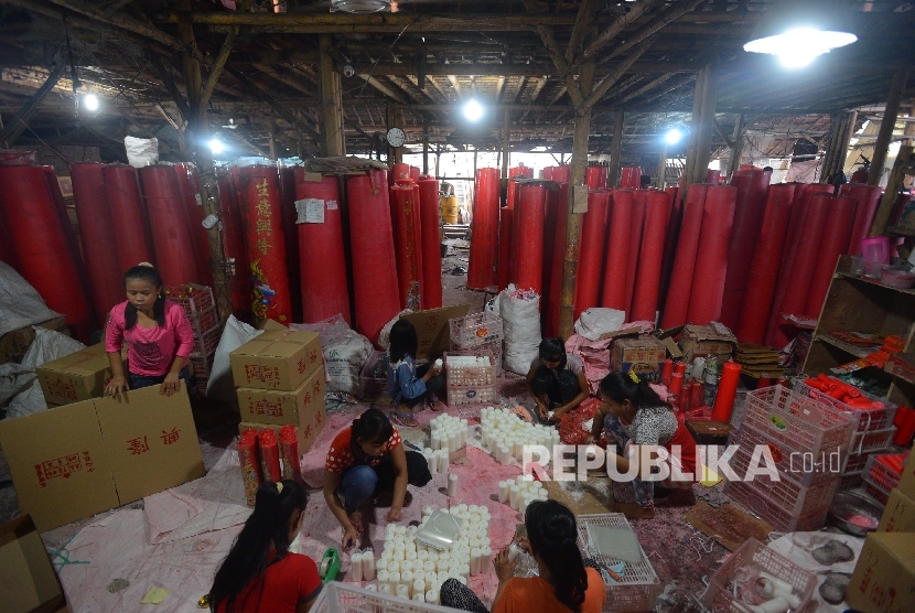 Pekerja melakukan pengepakan pada lilin yang telah diproduksi untuk perayaan Imlek di Teluk Naga, Tangerang, Banten, Kamis (28/1).