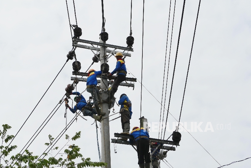 Pekerja melakukan pengerjaan perawatan dan peninggian jaringan kabel listrik PLN di Gombong, Jawa Tengah, Selasa (18/7).