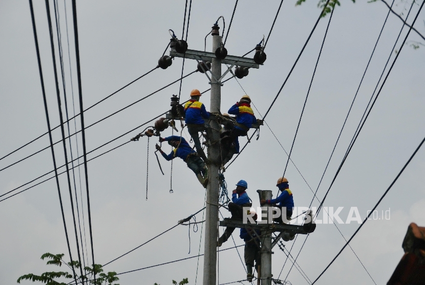 Pekerja melakukan pengerjaan perawatan dan peninggian jaringan kabel listrik PLN (ilustrasi)