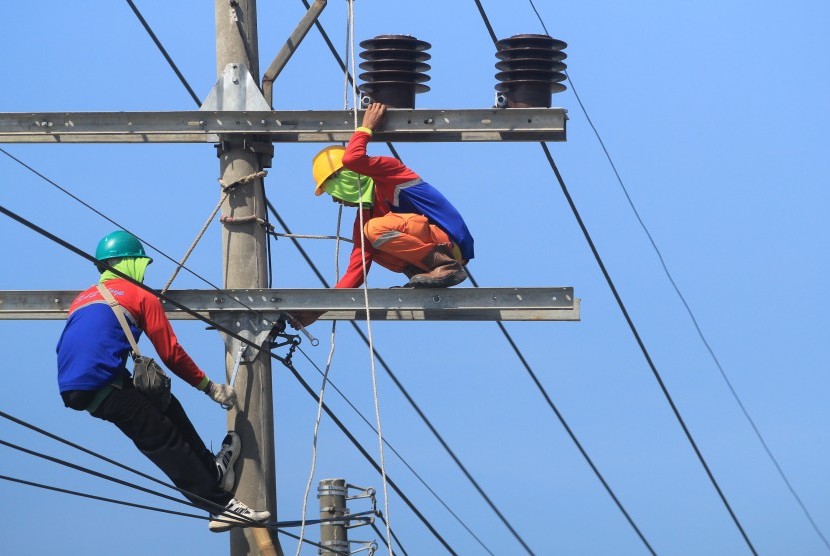 Pekerja melakukan perawatan jaringan listrik di jalur Pantura Lohbener, Indramayu, Jawa Barat, Selasa (28/5/2019).