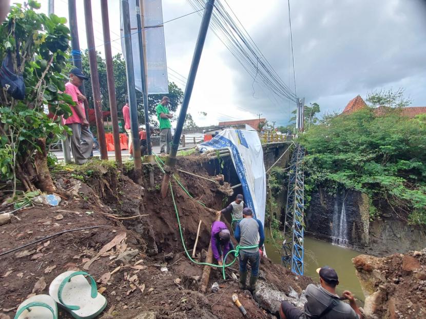 Pekerja melakukan perbaikan jembatan yang berada di Jalan Ahmad Yani, Kecamatan Tawang, Kota Tasikmalaya, Rabu (19/10/2022). Jembatan itu rusak akibat terdampak bencana pada September 2022.