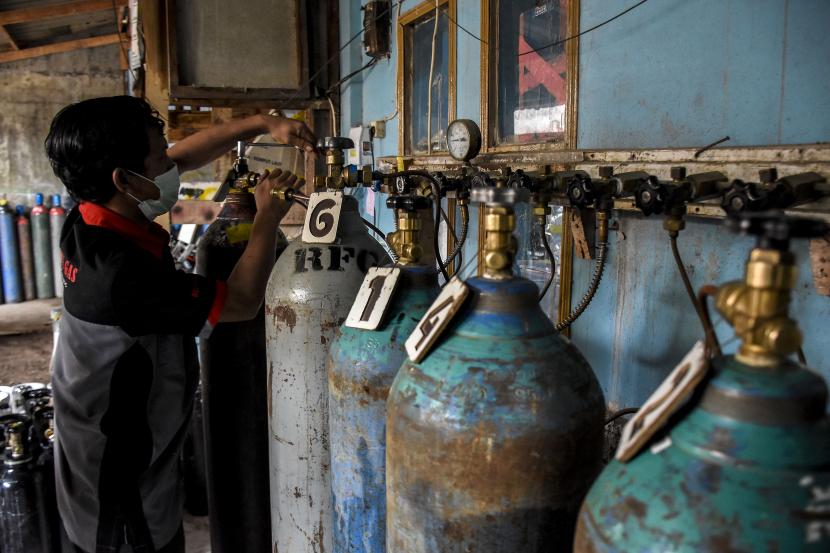 Pekerja melakukan proses isi ulang tabung oksigen di agen isi ulang oksigen, Jalan A H Nasution, Arcamanik, Kota Bandung.