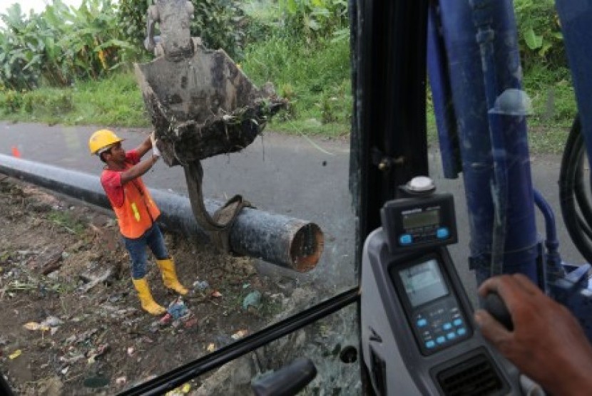 Pekerja melakukan proses penggalian, penurunan dan penimbunan pipa proyek Pertamina Gas, di kawasan Tol Belmera, di Medan, Sumatera Utara, Jumat (6/11). 
