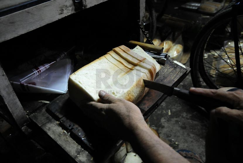 Pekerja melakukan proses tahap akhir pembuatan roti tawar usaha kecil menengah di Jakarta, Rabu (16/4).