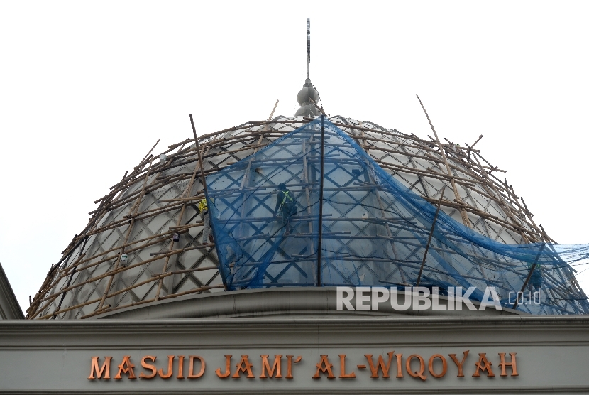  Pekerja melakukan renovasi kubah di Masjid Jami ALWiqoyah, Jakarta, Ahad (8/10). 