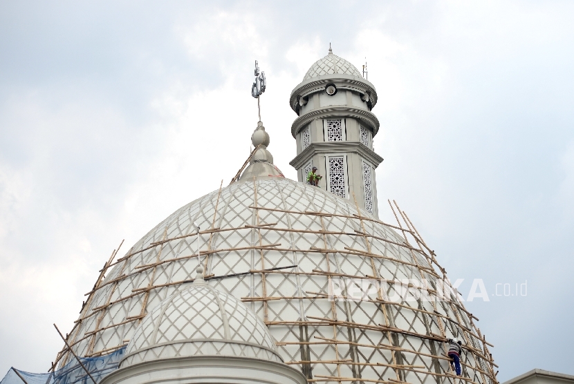 Pekerja melakukan renovasi kubah di Masjid Jami ALWiqoyah, Jakarta, Ahad (8/10). 