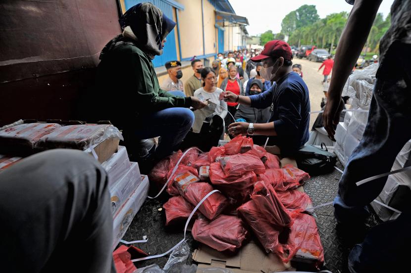 Pekerja melayani warga yang mengantre untuk membeli daging kerbau beku di Pasar Murah Perum Bulog.