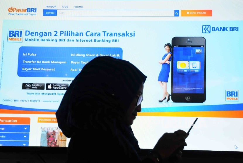  Pekerja melihat menu layanan BRI menggunakan smartphone di teras digital BRI di Gedung BRI, Jakarta.