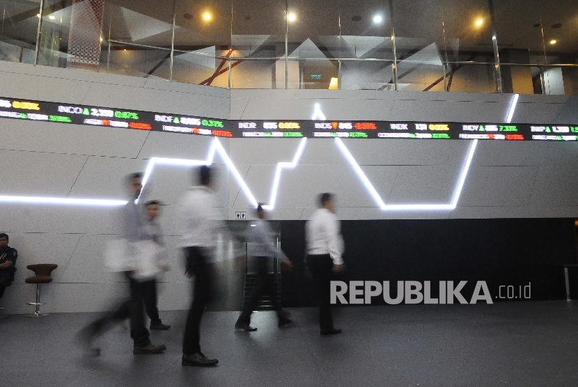 Pekerja melintas didekat layar pergerakan Indeks Harga Saham Gabungan (IHSG) di Gedung Bursa Efek Indonesia (BEI), Jakarta. ilustrasi