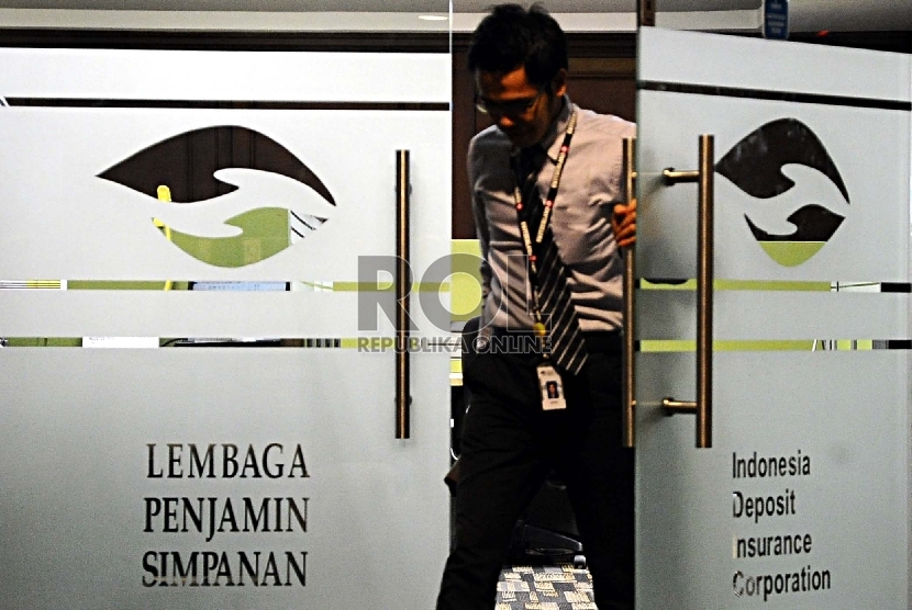  Pekerja melintas saat melakukan aktifitas di kantor Lembaga Penjamin Simpanan (LPS), Jakarta, Kamis (6/8).