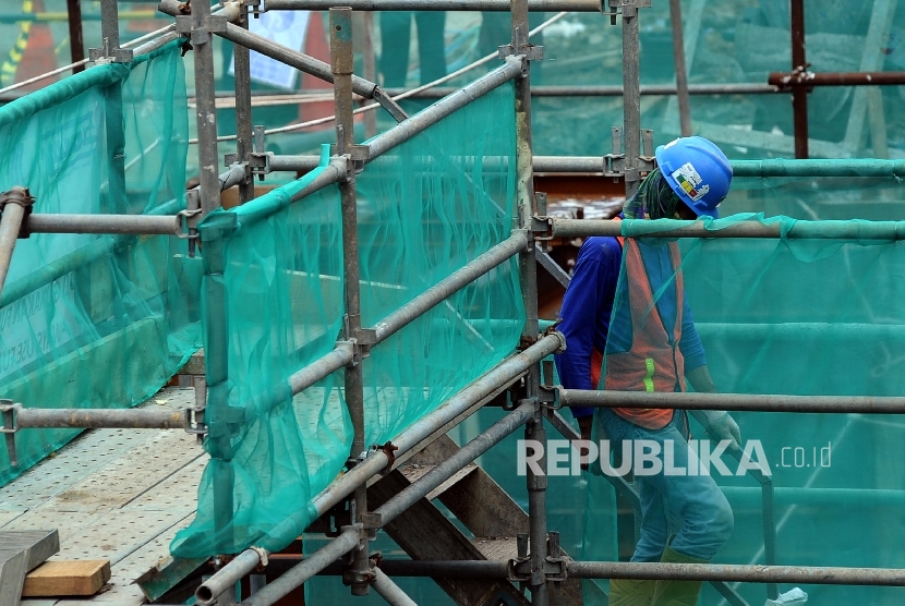  Pekerja melintas saat sedang menyelesaikan pembangunan infrastruktur di Jakarta, Selasa (7\2).