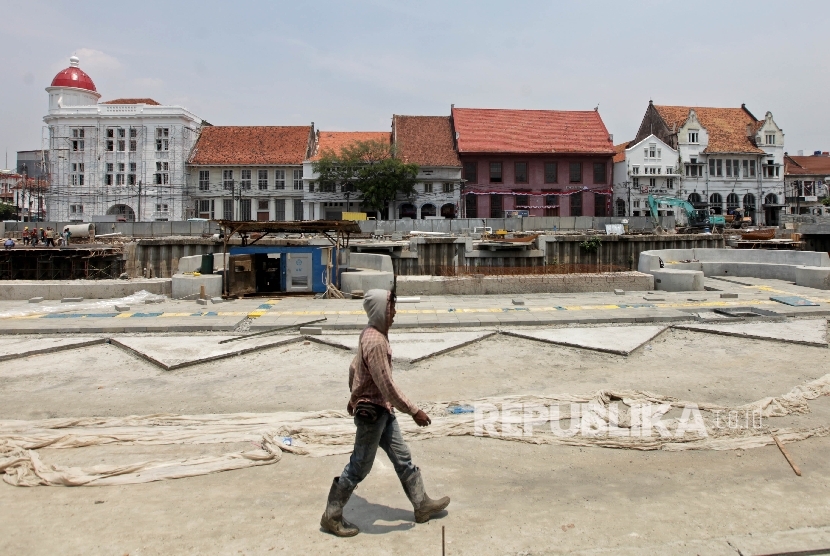  Pekerja melintasi proyek revitalisasi kawasan Kali Besar Kota Tua di Jakarta Barat, Rabu (13/9). 