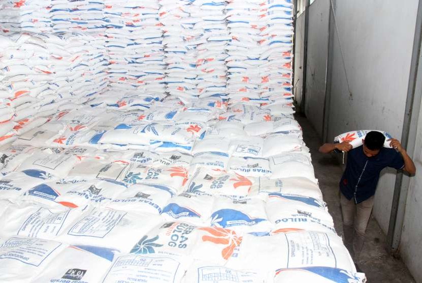 Pekerja memanggul beras cadangan milik pemerintah di gudang Perum Bulog. ilustrasi