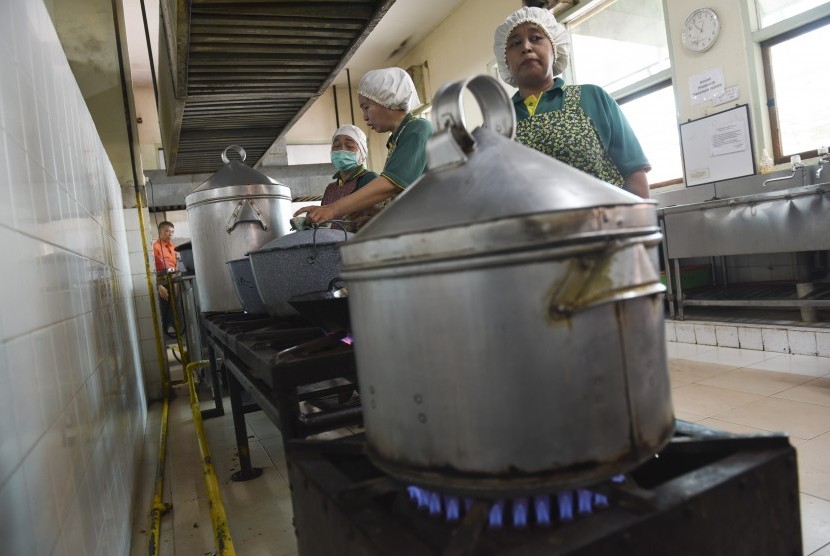 Pekerja memasak masakan pasien menggunakan gas PGN di dapur Rumah Sakit Darmo, Surabaya, Jawa Timur, Selasa (29/11).