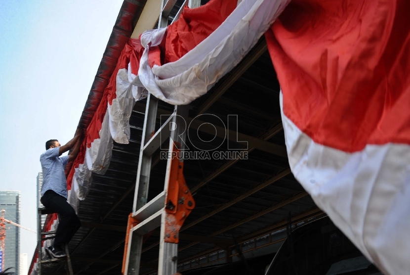  Pekerja memasang atribut merah putih di kawasan perkantoran Thamrin, Jakarta, Jumat (7/8). 