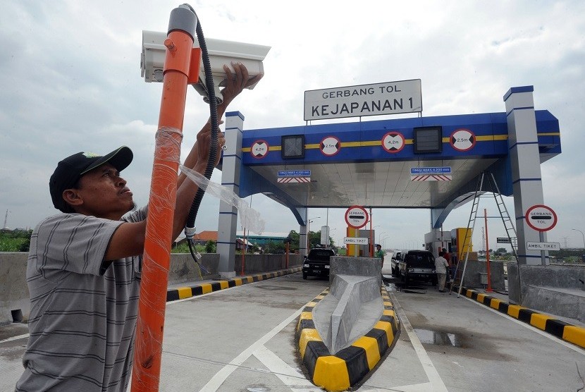 Pekerja memasang CCTV di depan pintu gerbang tol Gempol-Pandaan, di Kejapanan, Pasuruan, Jawa Timur, Jumat (13/2). PT Jasa Marga (Persero) Tbk mencatat kontribusi pendapatan tol naik 12 12,11 persen sebesar Rp 10,13 triliun pada 2019.