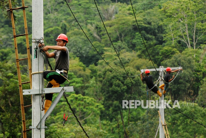 Pekerja memasang instalasi listrik di desa Kamiri, Barru, Sulawesi Selatan, Senin (15/1). 