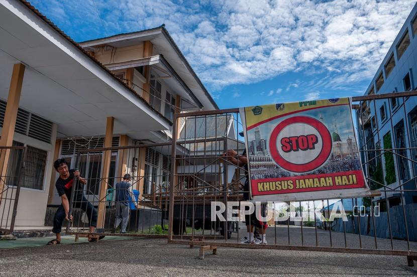 Pekerja memasang pagar barikade di jalan menuju gedung Asrama Haji Transit di Palu, Sulawesi Tengah.  Pemerintah setempat akan mengalihfungsikan asrama haji tersebut menjadi rumah sakit darurat penanganan COVID-19 menyusul kenaikan kasus positif di wilayah itu lebih dari 200 persen sejak Juli 2021.