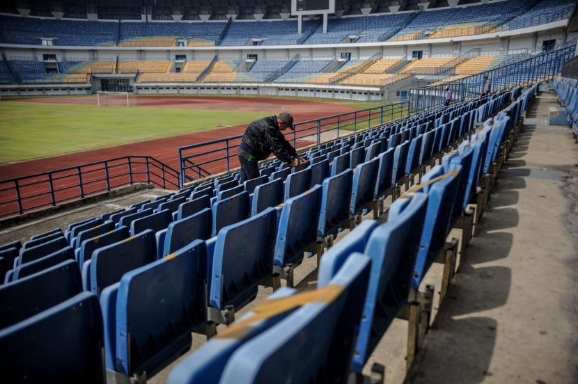 Pekerja memasang tanda dilarang duduk di tribun VIP Stadion Gelora Bandung Lautan Api di Gedebage, Bandung, Jawa Barat.