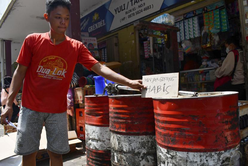 Pekerja memasang tulisan di atas drum minyak goreng curah di toko tradisional Pasar Caruban Baru, Madiun, Jawa Timur, Senin (21/3/2022). Menurut keterangan sejumlah pemilik toko tradisional stok minyak goreng curah di pasar tersebut kosong sejak seminggu terakhir karena tak adanya pasokan, sedangkan minyak goreng kemasan mengalami kelangkaan dengan stok terbatas yang dijual Rp23 ribu per liter.