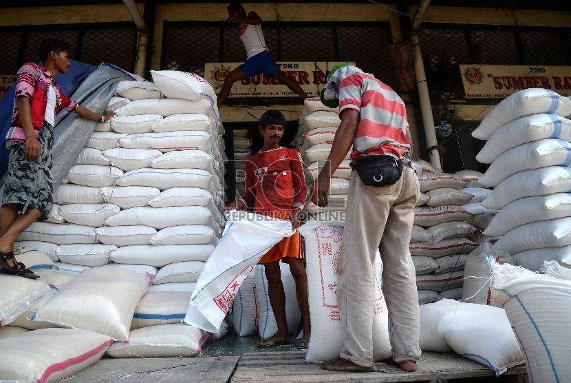 Pekerja memasukkan beras ke karung di Pasar Induk Cipinang, Jakarta Timur, Ahad (22/2).  (Republika/Yasin Habibi)