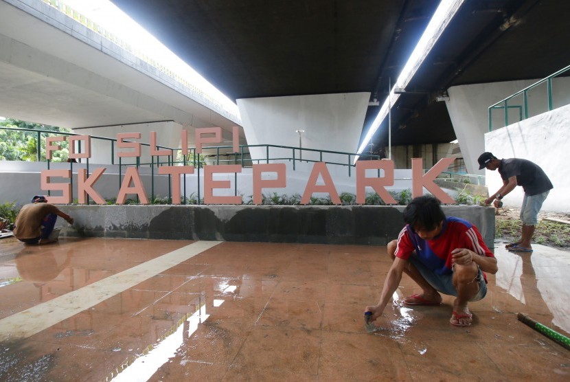 Pekerja membangun arena bermain papan luncur (Skateboard) di kolong Jembatan Layang Slipi, Jakarta, Jumat (14/12).
