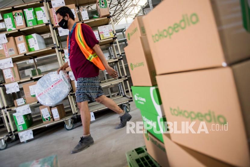 Pekerja membawa kemasan paket dari Tokopedia di Jakarta, Jumat (28/5/2021). 