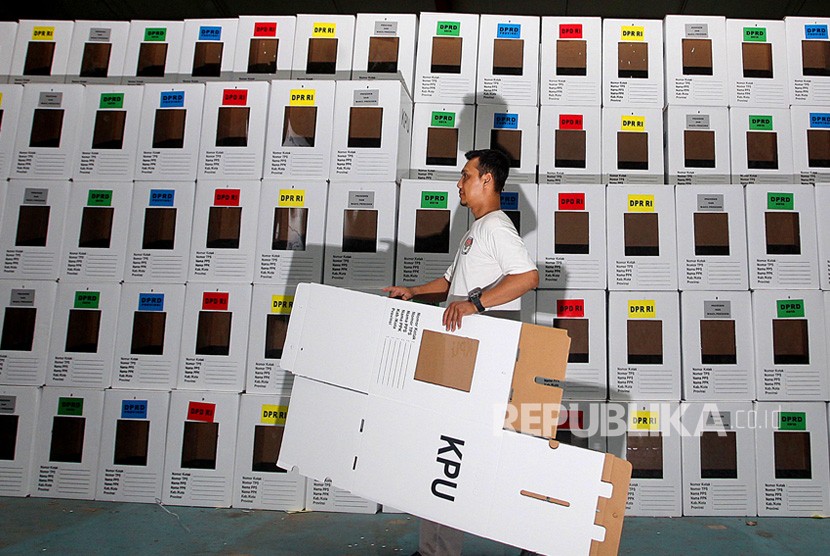 Pekerja membawa kotak suara yang dirakit di gudang logistik KPU Depok, Jawa Barat.