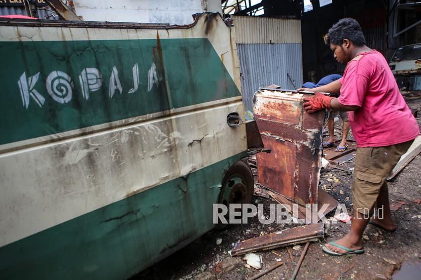 Pekerja membawa potongan bagian rangka bus Kopaja di Meruya, Jakarta, Kamis (28/1/2021). Bus Kopaja yang sudah tidak terpakai tersebut dihancurkan untuk dijual secara kiloan ke penjual besi tua.