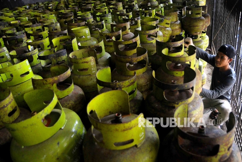 Pekerja membawa tabung gas elpiji tiga kilogram (gas melon) 