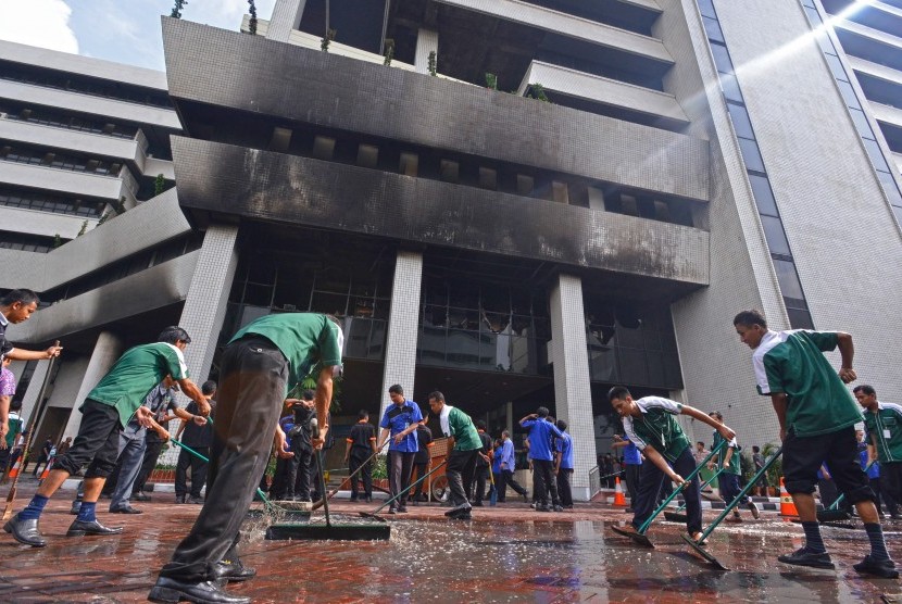 Pekerja membersihkan air sisa dari upaya pemadaman kebakaran di gedung RM Notohamiprodjo Radius Prawiro, komplek Kementerian Keuangan, Jakarta Pusat, Jumat (25/7). 