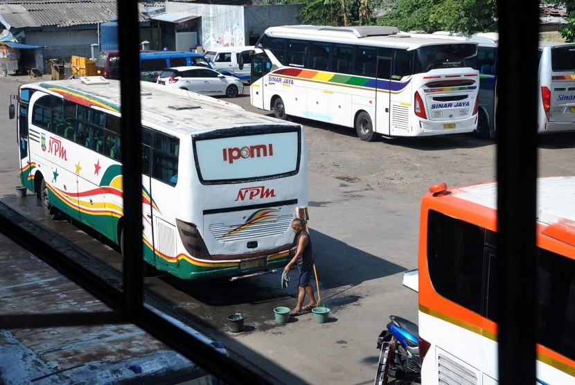 Pekerja membersihkan bagian belakang bus di Terminal Penumpang Tipe A Baranangsiang, Kota Bogor, Jawa Barat, Jum'at (19/7/2019).