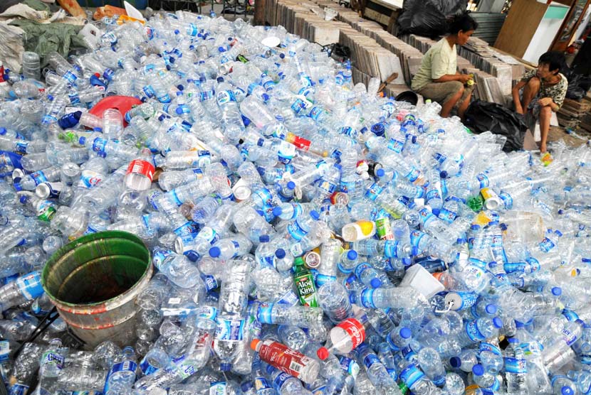 Pekerja membersihkan botol plastik bekas di penampungan botol bekas, Jakarta, Selasa (6/5).