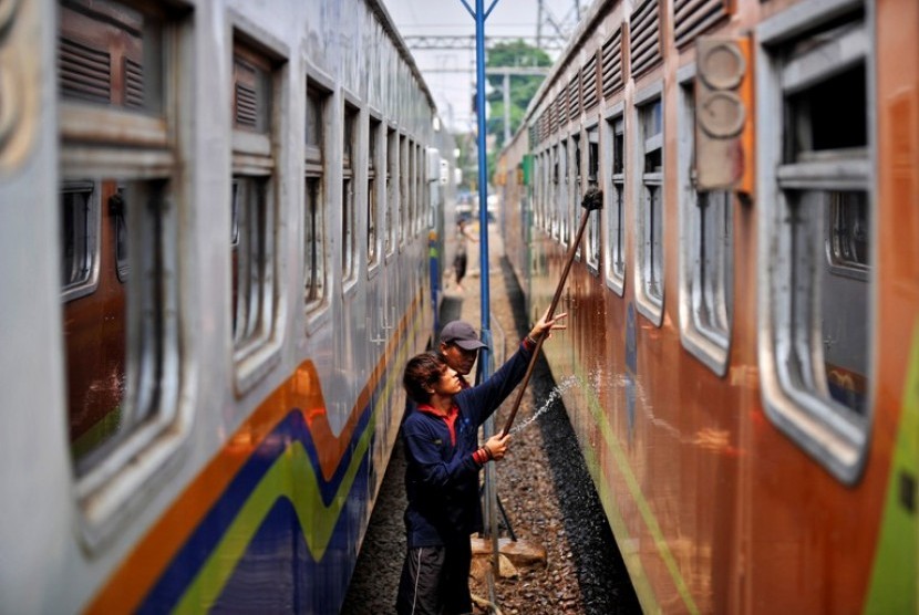 Pekerja membersihkan gerbong kereta api di Stasiun Pasar Senen, Jakarta, Minggu (12/8).