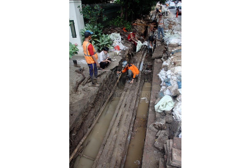 Pekerja membersihkan gorong-gorong di trotoar jalan H. Agus Salim, Jakarta Pusat, Selasa (25/3).