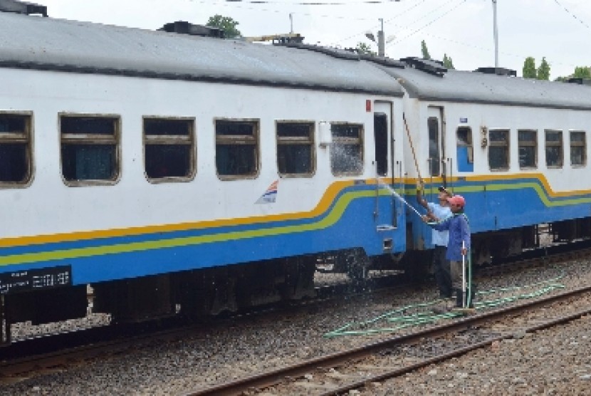   Pekerja membersihkan Kereta Api (KA) di Stasiun KA Madiun, Jatim, Selasa (23/12).