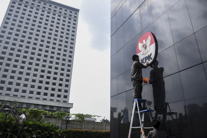 Pekerja membersihkan logo KPK, di Gedung Merah Putih, Jakarta