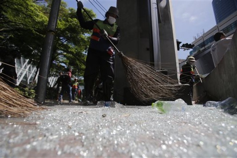 Pekerja membersihkan pecahan kaca akibat ledakan di Kuil Erawan persimpangan Rajprasong, Bangkok, Thailand, Selasa (18/8).