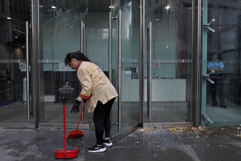 Pekerja membersihkan pintu masuk utama Markas Polisi Hong Kong yang dilempari telur oleh pengunjuk rasa di Hong Kong, Sabtu (22/6). Massa penentang aturan ekstradisi membubarkan diri dengan damai setelah menggelar protes selama satu malam.