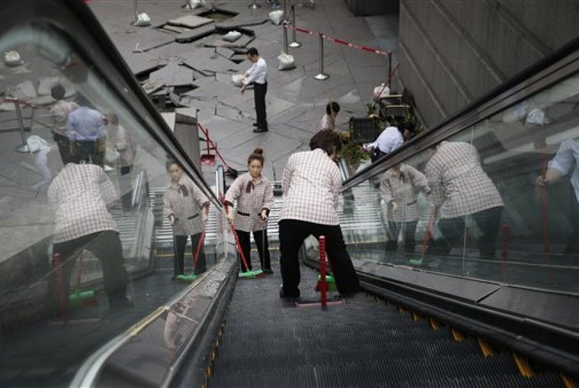 Pekerja membersihkan puing-puing di eskalator di pintu masuk gedung Taipei101 yang rusak karena Topan Dujuan di Taipei, Taiwan, Selasa (29/9). 