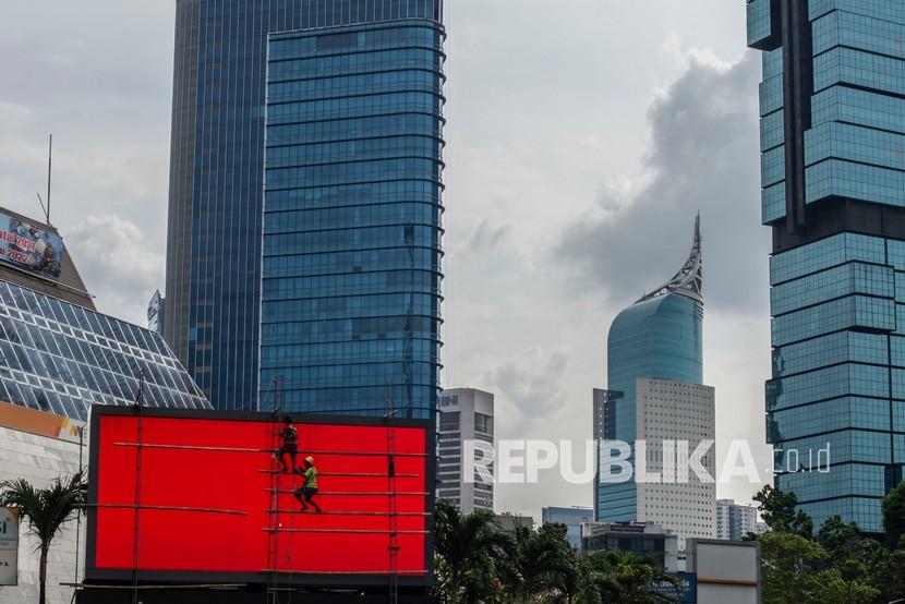 Pekerja membersihkan videotron di Jakarta, Sabtu (8/1/2022). Ombudsman RI mengkritik program Bantuan Subsidi Upah (BSU) pengalihan subsidi BBM karena hanya diperuntukkan bagi pekerja formal peserta BPJS Ketenagakerjaan. 