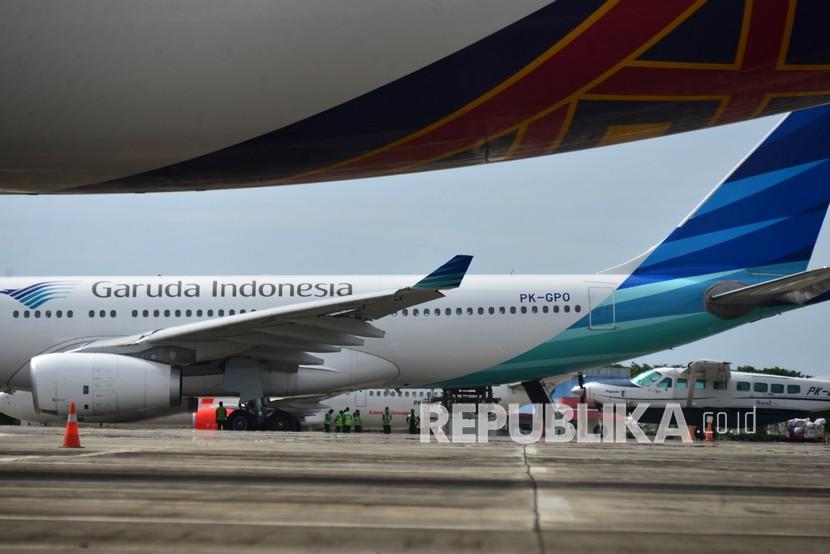 Pekerja membongkar muat kargo dari pesawat Garuda Indonesia setibanya di Bandara Internasional Sultan Iskandar Muda (SIM), Blang Bintang, Kabupaten Aceh Besar, Aceh. Garuda tekan kerugian hingga 224,14 juta dolar AS atau turun 42 persen yoy. Ilustrasi.