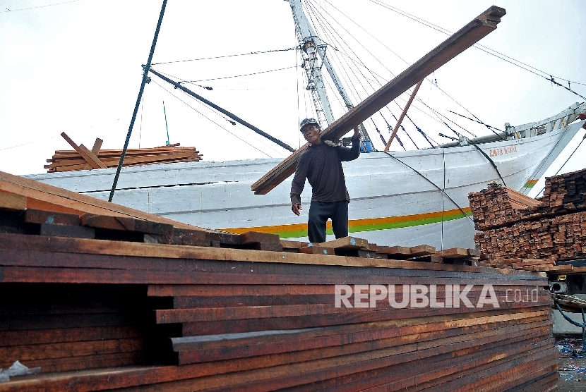  Pekerja membongkar muatan kayu dari Kalimantan di Pelabuhan Sunda Kelapa, Jakarta.