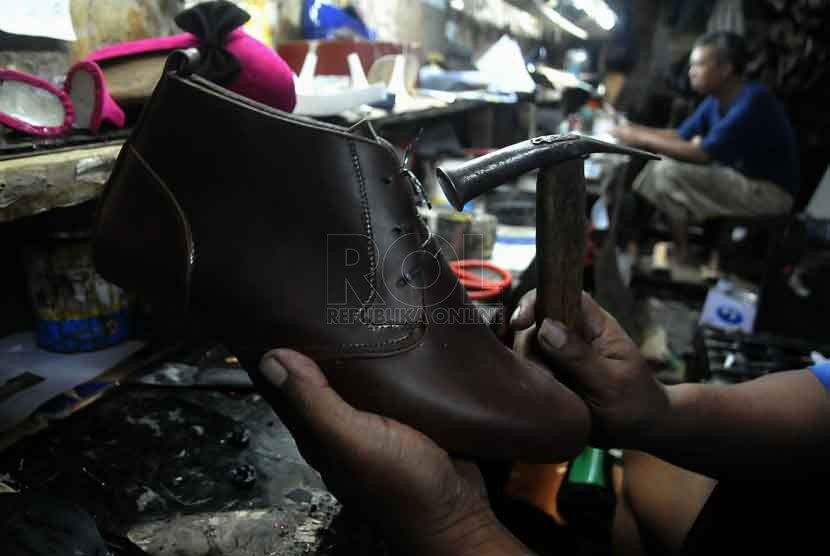 Pekerja membuat sepatu pesanan di tempat produksi rumahan di Kawasan Kuningan, Jakarta, Jumat (26/9).(Republika/Prayogi)